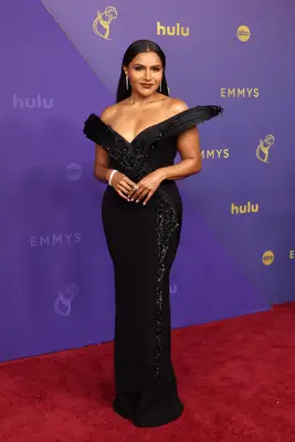 Mindy Kaling wears a black gown with statement off-the-shoulder neckline to the 2024 Emmys