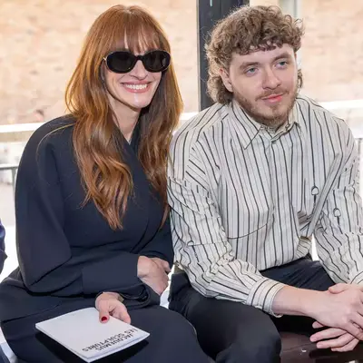 Julia Roberts with wispy fringe bangs sitting next to jack Harlow at the Jacquemus fashion show