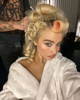 Sabrina Carpenter takes a selfie while getting her hair and makeup done.