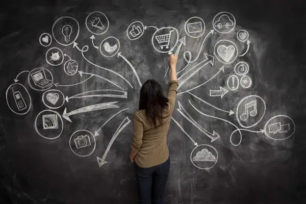 woman drawing social media icons on a chalkboard