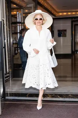 Pamela Anderson walks around with vintage curls and a wide-brimmed hat.