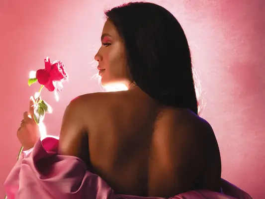 Monet McMichael holding a rose wearing pink off-the-shoulder dress