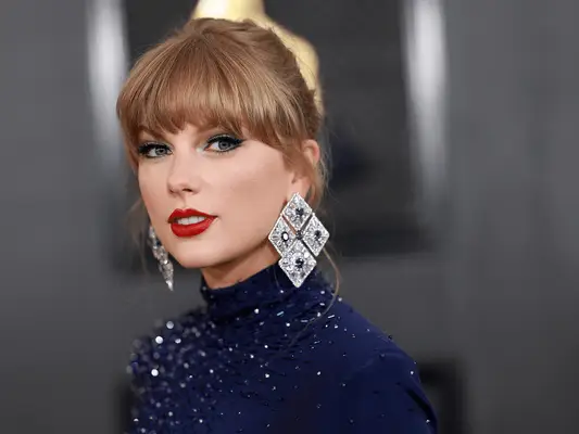 Taylor Swift wearing cat eye eyeliner and a blue gown