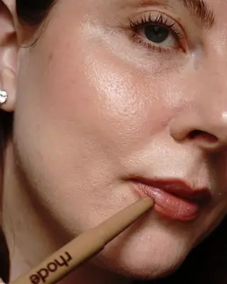 Woman applying lip liner on her lips