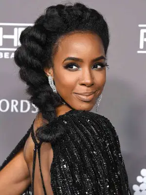 Kelly Rowland attends an event in LA wearing a natural side braid and sequined dress