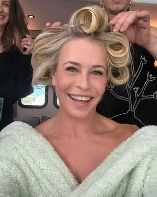 Chelsea Handler smiling, with rollers in her hair