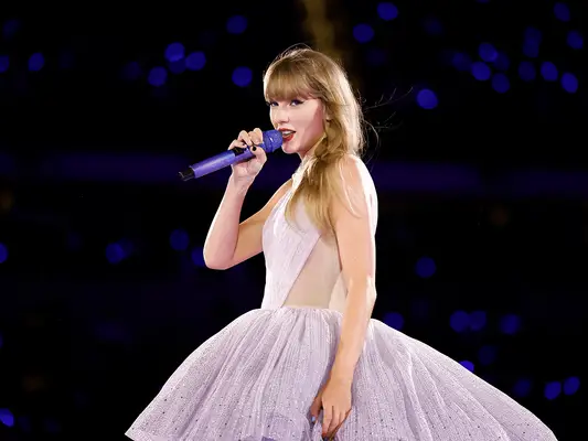 Taylor Swift on stage in a purple gown