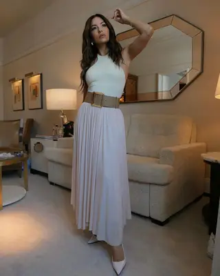 Eva Longoria wearing a white top and pink skirt. 