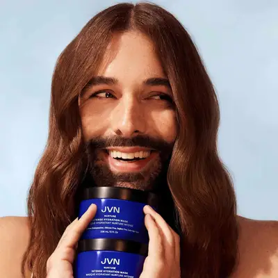 Jonathan Van Ness portrait with him smiling while holding his moisturizing hair mask.