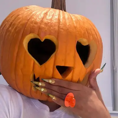 Megan Thee Stallion wearing a pumpkin head. 