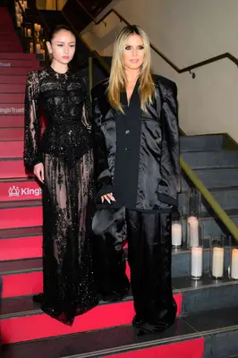 hiedi klum and daughter posing in black outfits on red stairs 