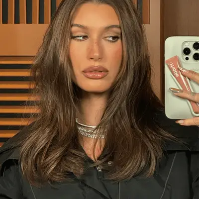 Hailey Bieber sitting next to Justin Bieber at the Super Bowl with brand new dark chocolate brown hair