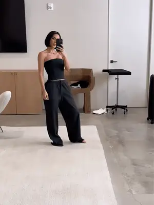 kim kardashian wearing a 90s bob with a skims corset and track pants
