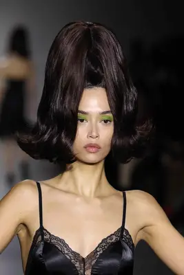 model with sky-high ponytail and bright green eyelids