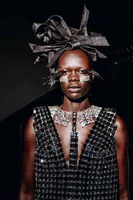 Model backstage at Thom Browne show with elaborate sculptural ribbon hair