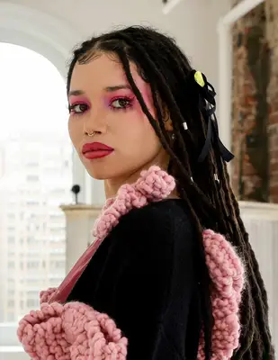 a model with bright pink eyes and bold lips at Melke