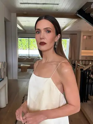 Mandy Moore looks into the camera, showing off her reddish makeup and dark blurred lip.