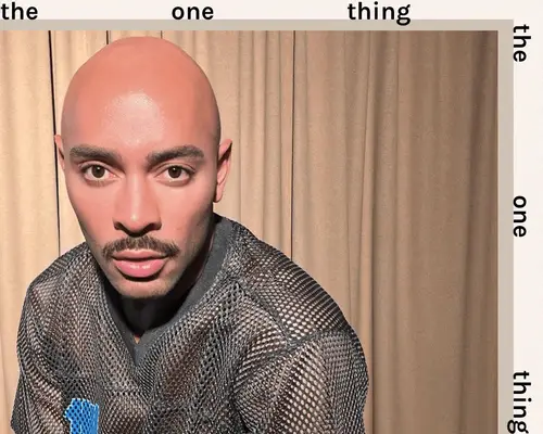 makeup artist sir john taking a selfie on tan backdrop