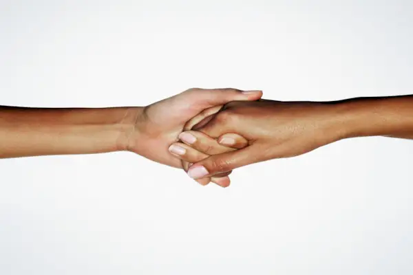 Two young women linking hands, close up