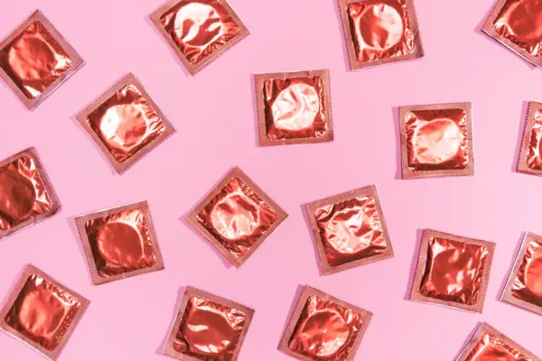 Top view condoms red wrappers,Directly above shot of pink desserts on pink background
