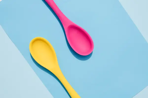 Bright colored spoons on a colored background.