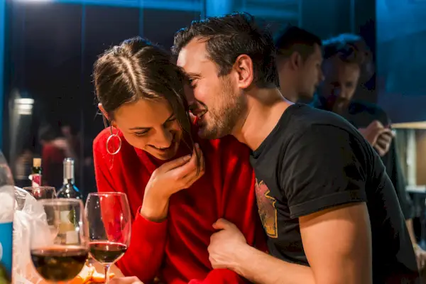 Couple drinking wine at party in apartment