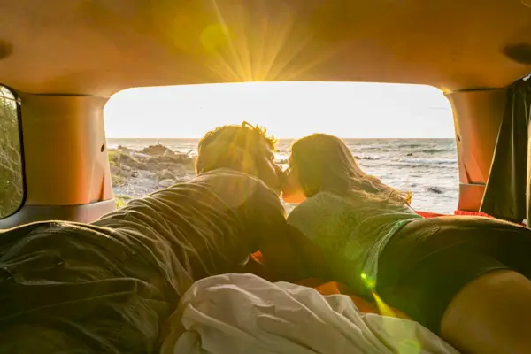 Couple kissing in a van, New Zealand.