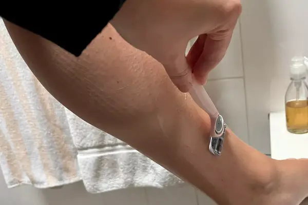 Hand using a Joy Razor to shave their leg