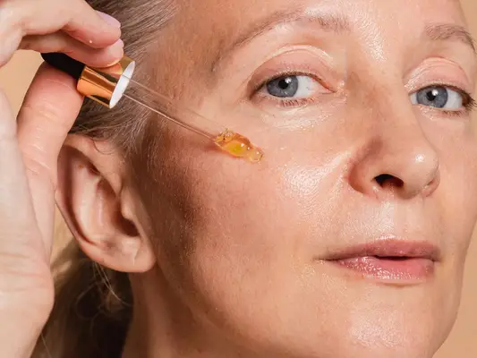 woman applying skincare serum to her face