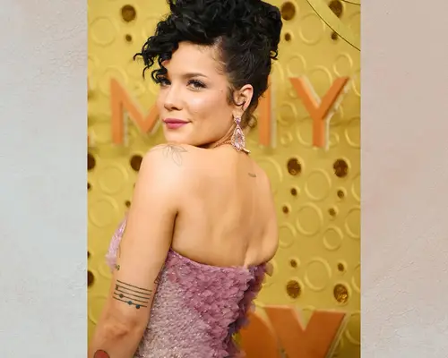 The singer Halsey with a sheet music tattoo on her arm