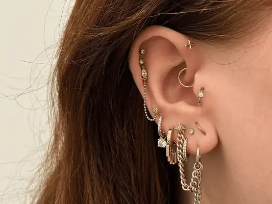 An ear with multiple piercings including the tragus