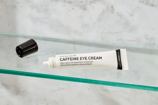 Tube of The Inkey List Caffeine Eye Cream on a glass shelf