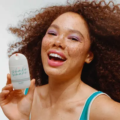 Model holding Vacation Shake Shake sunscreen