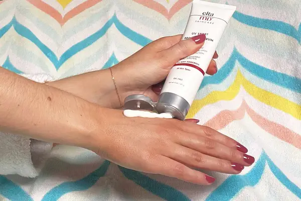 Hand applying EltaMD UV Sport Broad-Spectrum SPF 50 Sunscreen on to the back of other hand 
