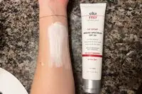 Arm covered with EltaMD UV Sport Broad-Spectrum SPF 50 Sunscreen next to the tube 