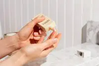 Hand dispensing Summer Fridays ShadeDrops Broad Spectrum SPF 30 Mineral Milk Sunscreen onto fingertip