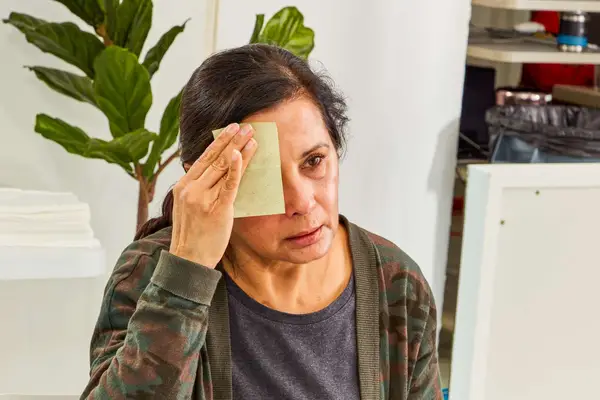 Hand blotting forehead with blotting paper