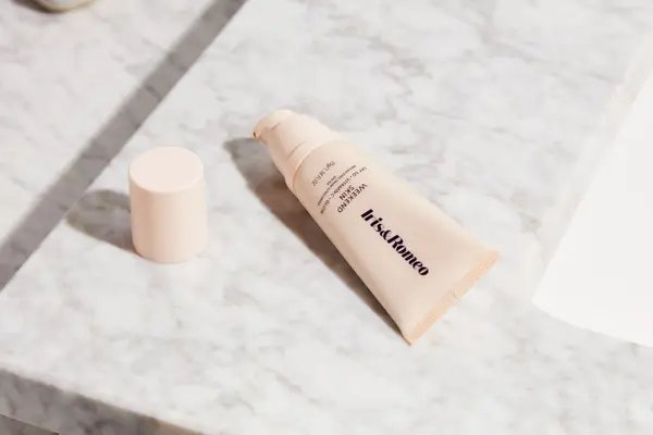 Iris & Romeo Weekend Skin SPF 50 + Vitamin C + Glow with cap on marble counter