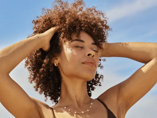 Confident woman enjoying the sun at beach vacation