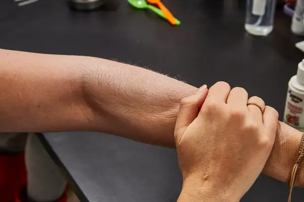 Person sitting with their arms crossed over one another