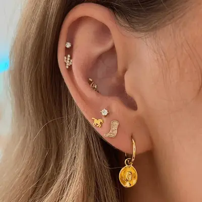 Close up of an ear with Western themed earrings.