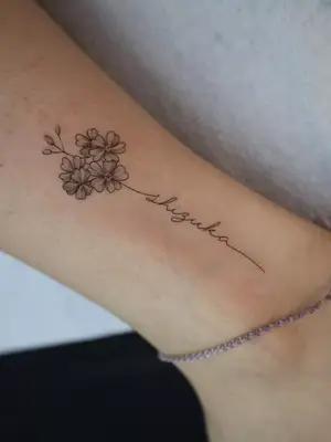 close up of tattoo on limb of three flowers and instead of stem it