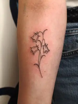 close up of bluebells tattoo in black ink on forearm