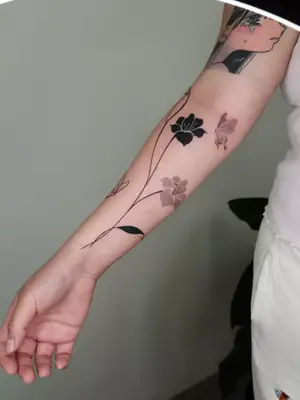 close up of purple and black ink tattoos going up length of forearm