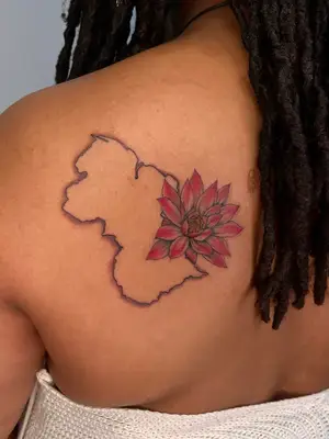 close up of tattoo on left back and shoulder area, outline of Guyana country with red flower on top