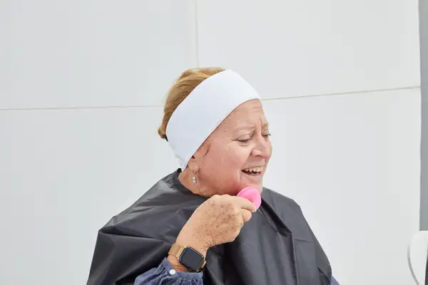 A person using the RoseSkinCo. Petal 2 Ultrasonic Facial Cleansing Brush on their face