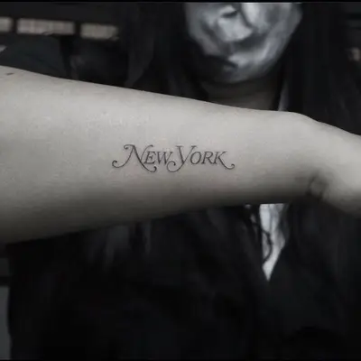 A forearm with a tattoo that reads 