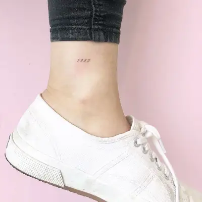 Year date word tattoo on ankle
