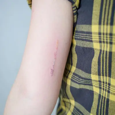 Gradient rainbow lettering tattoo