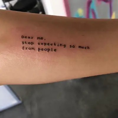 Ad Meliora script word tattoo behind the ear